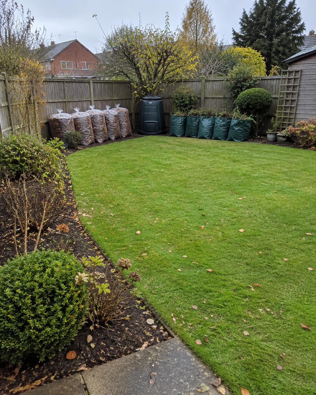 A back garden after an autumn tidy-up with raked lawn and cleared borders